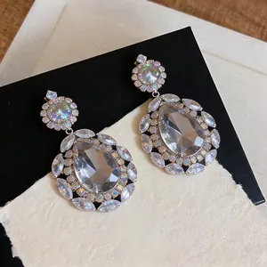 Detailed macro view of vintage court-style teardrop earrings with clear crystal stones.