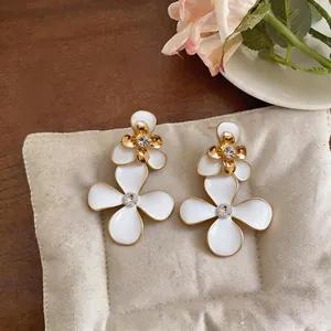 Foto de detalle de pendientes de flores esmaltadas con centro de diamantes de imitación