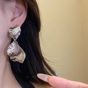 Macro detail view showing the texture of vintage silver pleated metal petal earrings on ear