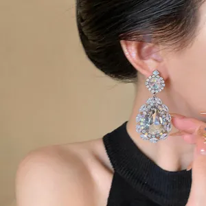 Close-up of elegant waterdrop earrings with sparkling rhinestones on an Asian model