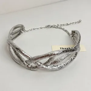 Close-up of textured silver-toned intertwined metal choker with adjustable chain
