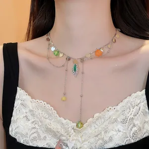 Detailed view of a French style necklace with colorful beads and charms on a model