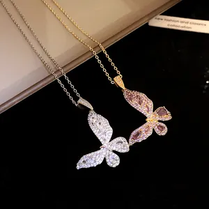 Macro detail of two zircon butterfly pendant necklaces in gold and silver with sparkling stones