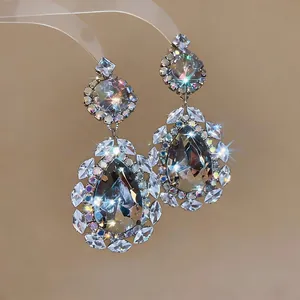 Detailed view of ornate waterdrop earrings with sparkling rhinestones in vintage style.