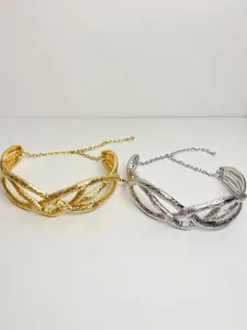 Detailed view of gold and silver twisted metallic choker necklaces with wrinkled texture.