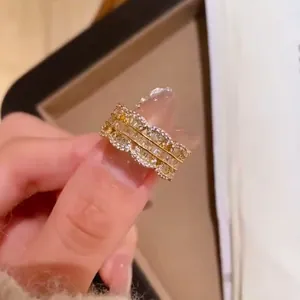 Dettaglio di un anello aperto retrò francese con bordi ondulati e zirconi brillanti