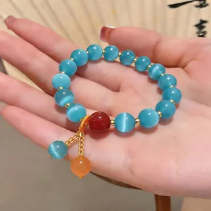 Elegante bracciale di perline occhio di gatto blu con pietra rossa e ciondoli
