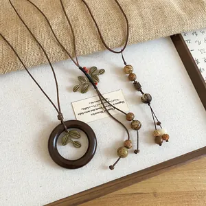 Detailed view of retro ethnic style necklaces with wooden ring and leaf pendants