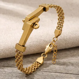 Detail van een gevlochten goudkleurige roestvrijstalen armband met gepolijste gebogen bar