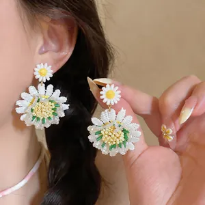 Pendientes de margaritas hechos a mano con abalorios, pétalos blancos y centro amarillo