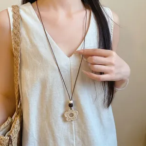 Ethnic style wax cord necklace featuring wood beads and a geometric resin flower pendant