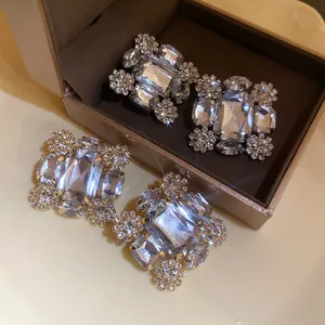 Elegante Nahaufnahme von funkelnden quadratischen Strass-Ohrclips in Schmuckschatulle