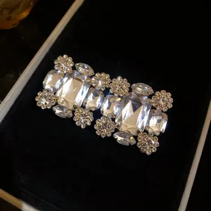 Nahaufnahme eleganter Strass-Clip-Ohrringe mit großen rechteckigen Kristallen in schwarzer Box.
