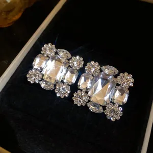 Detailaufnahme luxuriöser quadratischer Kristallohrringe mit funkelndem Strass-Cluster