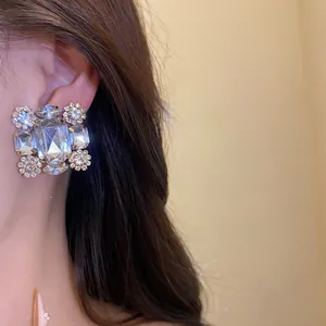Nahaufnahme von funkelnden quadratischen Strass-Ohrclips an einem asiatischen Model