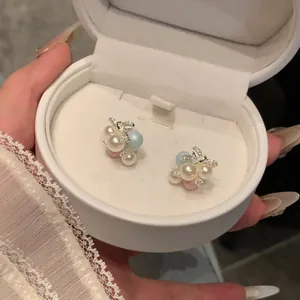 Elegant bowknot stud earrings with colorful pearls presented in a white jewelry gift box