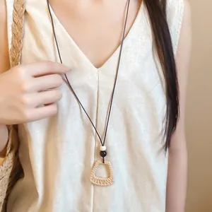 Close-up of a folk-style wax cord necklace with geometric resin pendant on a model