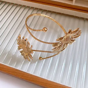 Close-up of golden pleated flower armlet bangle with intricate sunflower petal details