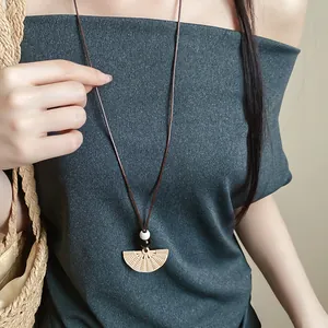 Close-up of ethnic style fan pendant necklace with resin texture and wooden beads