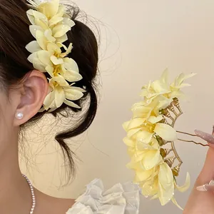 Detail view of a pale yellow floral hairpin for elegant bun styling and cheongsam accessories.