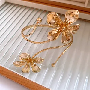 Close-up of gold pleated flower armlet with intricate metal petal texture