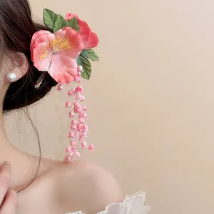 Detailed macro view of a pink lily of the valley flower hair clip with elegant tassels