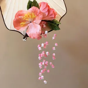 Detailed view of an elegant pink lily of the valley tassel hair clip for Hanfu dress