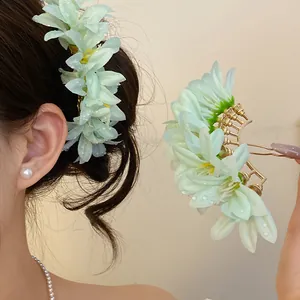 Detailed view of an elegant mint green flower hair fork shown both in hair and in the hand.