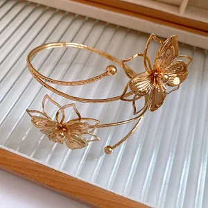 Close-up of elegant gold pleated flower armlet with textured petal metal details