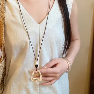 Detailed shot of ethnic fan-shaped pendant necklace with wax cord and wood beads