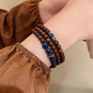 Close-up detail of a vintage-style wooden and blue stone bead bracelet on a wrist