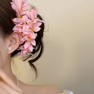 Detailed close-up view of a pink floral hair accessory styled in a traditional updo