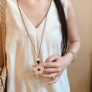 Detail view of ethnic flower pendant necklace with resin texture and wood beads
