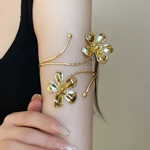 Macro detail showing the exquisite pleated flower texture of this gold metal arm cuff jewelry.