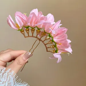 Detail of pink floral hair pin with gold U-shaped fork for traditional hairstyles