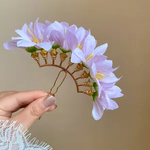 Detailed view of a purple flower hair fork with dewdrop accents for bun hairstyles