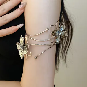 Close-up detail of a metallic wrinkled flower arm cuff featuring an elegant silver finish