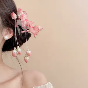 Close-up of pink floral tassel hair clip worn on bun for Hanfu or Qipao