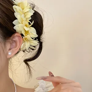 Detailed view of a vintage floral hair pin with dewdrop accents in an elegant hairstyle.