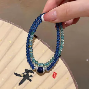 Close-up of double-layered blue beaded bracelet with silver metal accents