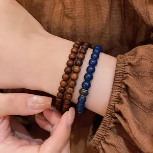 Close-up of retro layered beaded bracelets featuring blue stones and dark wood beads