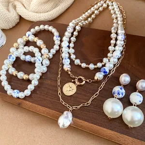 Vintage style jewelry set with pearls and ceramic beads on a wooden display board