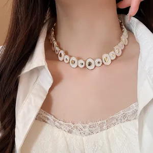 Close-up detail of vintage white enamel irregular round choker necklace on model