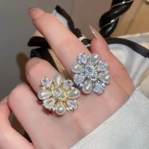 Detailansicht von blumenförmigen Ringen mit funkelnden Zirkonen und eleganten Perlen