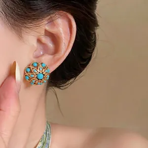 Vintage 18k gold plated hollow flower stud earrings with turquoise beads on model