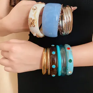 Detail view of various stackable bohemian resin bangles in retro styles and colors