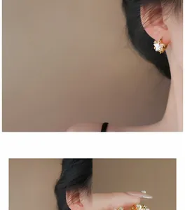 Detailed view of elegant pink star and pearl earrings worn by a model for a stylish look.