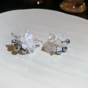 Nahaufnahme eleganter Blumen-Ohrstecker mit Perlmuttblüten und Zirkonia-Perlen-Details