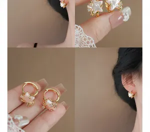 Detail view of pink star hoop earrings with pearl-like finish and gold accents