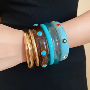 Detailed close-up of stacked retro resin bangles featuring colorful stone embellishments